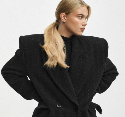 Kobieta z gładko spiętymi, lśniącymi blond włosami w eleganckim kucyku.